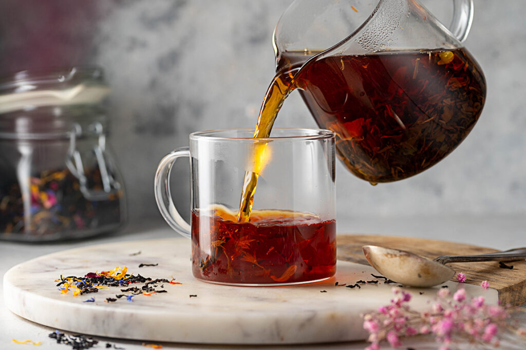 a cup of black tea and loose leaves