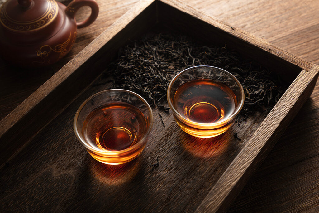 cups of oolong tea and loose leaves