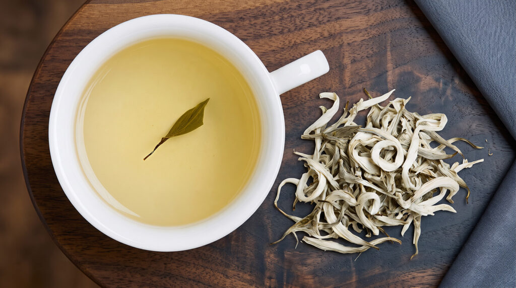 a cup of white tea and loose leaves
